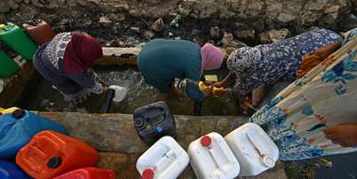 Mulheres recolhem &aacute;gua de fonte nas montanhas de Bizerte, Tun&iacute;sia, em 21 de julho de 2026. Foto: AFP - FETHI BELAID / RFI