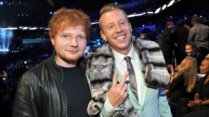 O vocalista da banda Gorillaz, Damon Albarn, segura uma bandeira palestina durante um show após a remoção de Macklemore do tour.