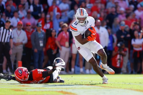 Keshaun Singleton of Auburn runs with the ball past a fallen Georgia defender