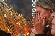 Mulher reza no Santuário de Nossa Senhora de Aparecida, em SP