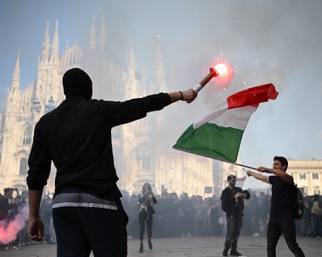 A protester with a burning flare and other waving an Italian flag