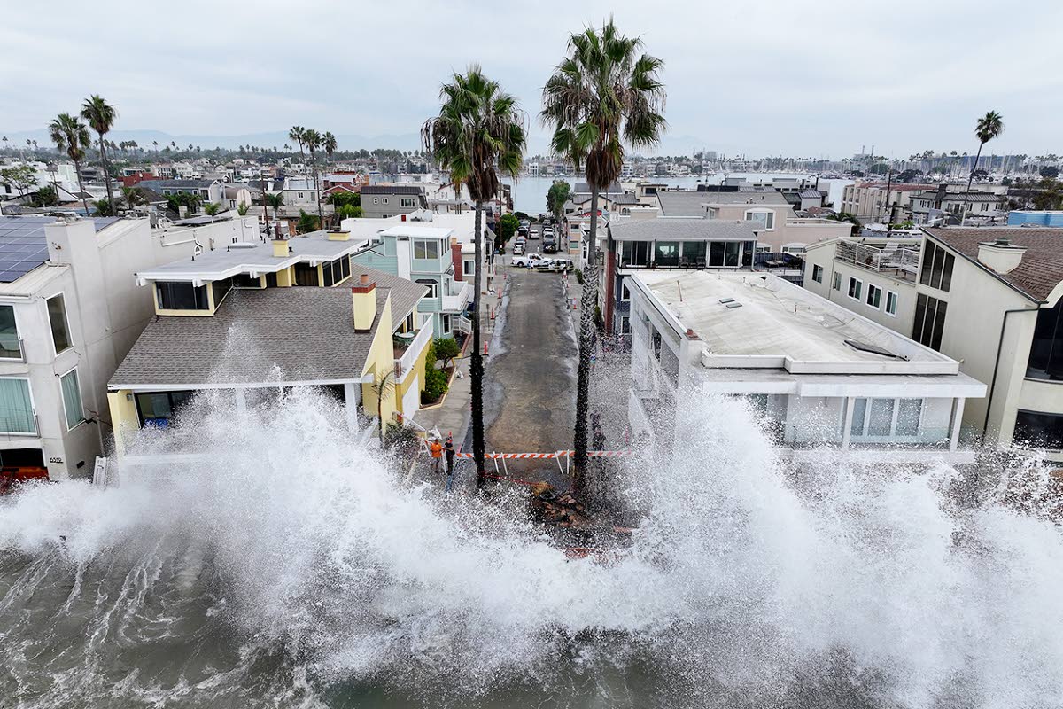 Waves hit a walkway in front of homes in Long Beach, California, Saturday, October 10, 2026, as Tropical Storm Rachel approaches. (AP Photo/William Liang)